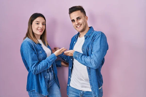 Unga Latinamerikanska Par Står Över Rosa Bakgrund Inbjudande Att Komma — Stockfoto