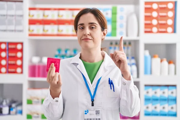 Brunette Woman Working Pharmacy Drugstore Holding Condom Surprised Idea Question — Stock Photo, Image