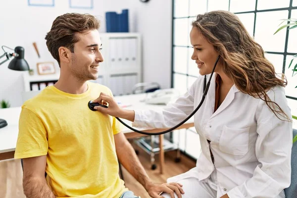 Man and woman having doctor visit examining using stethoscope at clinic