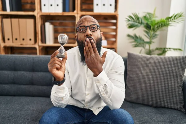 African American Man Holding Sand Clock Office Covering Mouth Hand — Stockfoto
