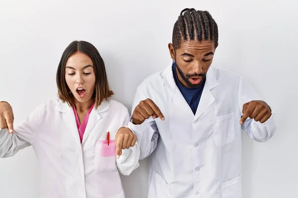 Young Hispanic Doctors Standing White Background Pointing Fingers Showing Advertisement —  Fotos de Stock
