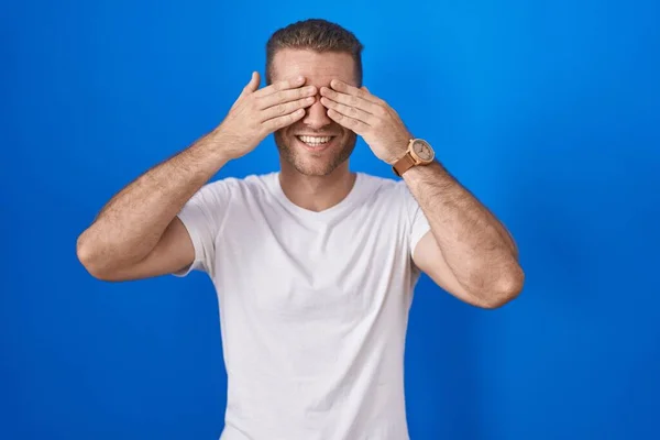 Young Caucasian Man Standing Blue Background Covering Eyes Hands Smiling — Stock Photo, Image
