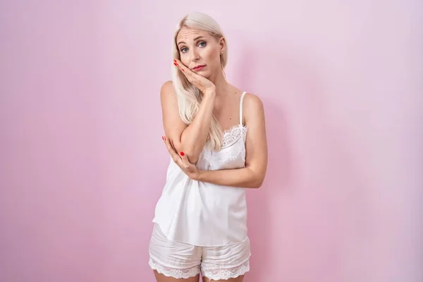 Běloška Nosí Pyžamo Sobě Růžové Pozadí Myšlení Vypadat Unaveně Znuděný — Stock fotografie