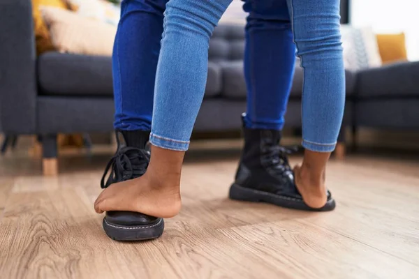 Father and daughter stepping on foot dancing at home