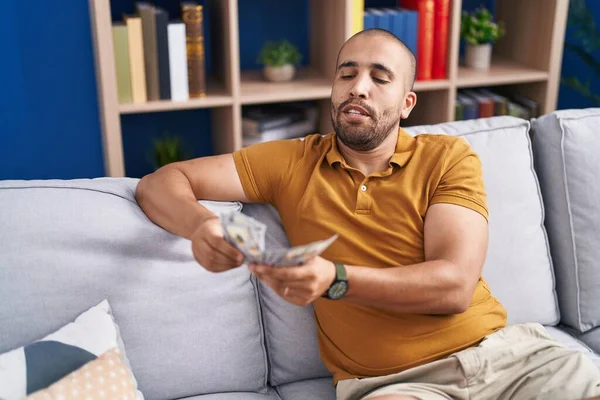 Mladý Latinský Muž Počítá Dolary Sedí Doma Pohovce — Stock fotografie