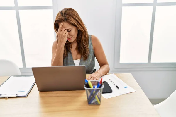Young latin woman business worker stressed suffering for headache at office