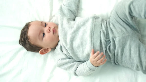 Urocze Latynoskie Dziecko Leżące Łóżku Relaksującym Wyrazem Twarzy Sypialni — Zdjęcie stockowe