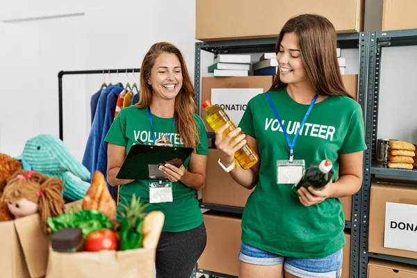 Mother Daughter Wearing Volunteer Uniform Writing Checklist Working Charity Center — Stock Photo, Image