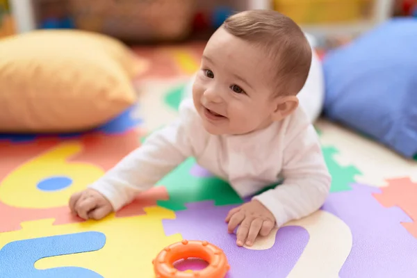 Liebenswertes Kleinkind Lächelt Kindergarten Selbstbewusst Auf Dem Boden Liegend — Stockfoto
