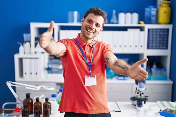 Young Hispanic Man Working Scientist Laboratory Looking Camera Smiling Open — стоковое фото