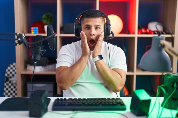 Young Hispanic Man Playing Video Games Afraid Shocked Surprise Amazed — Foto de Stock