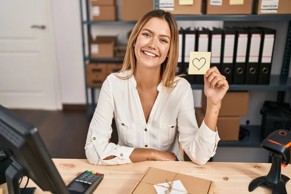 Young Blonde Woman Working Small Business Ecommerce Holding Heart Note — Stock Photo, Image