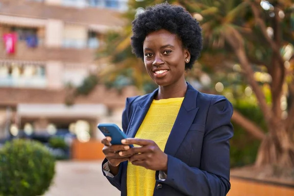 Young african american woman business executive using smartphone at park
