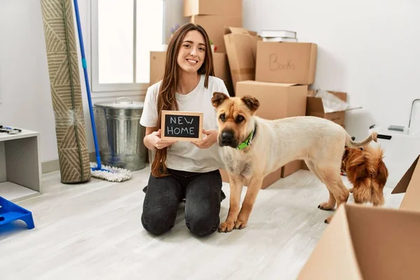 Young Hispanic Woman Holding New Home Blackboard Sitting Floor Dogs — стоковое фото