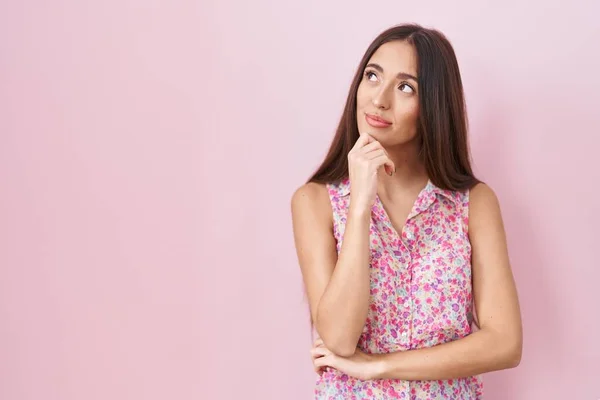 Young Hispanic Woman Long Hair Standing Pink Background Hand Chin — Stockfoto