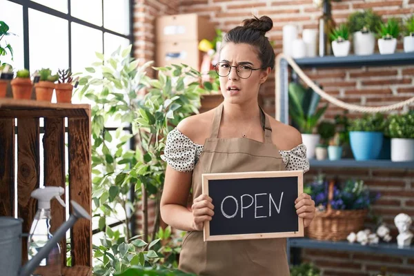 Hispanic Woman Working Florist Holding Open Sign Clueless Confused Expression — Stockfoto