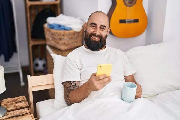 Young Bald Man Using Smartphone Drinking Coffee Bedroom — Stock Photo, Image