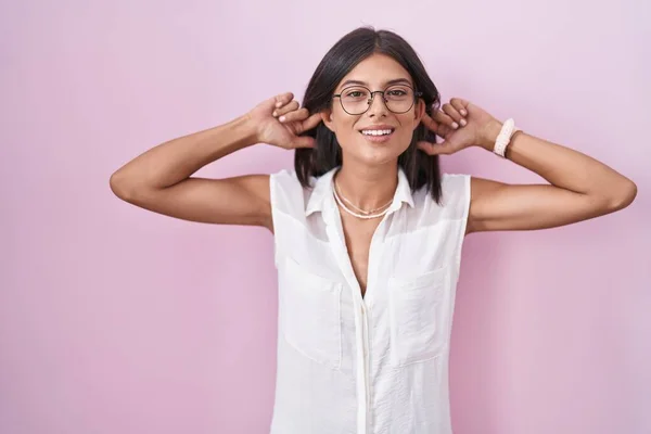 Brunette Young Woman Standing Pink Background Wearing Glasses Smiling Pulling — Stock fotografie