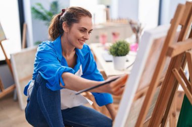 Young woman artist smiling confident drawing at art studio