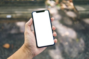 Elinde akıllı telefon tutan adam sokakta beyaz beyaz ekran gösteriyor