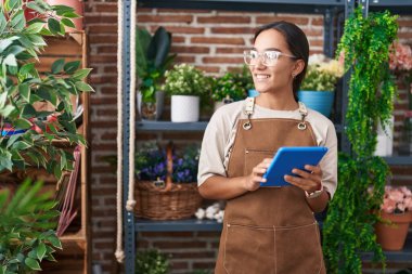 Çiçekçiye dokunarak gülen güzel İspanyol kadın çiçekçi.