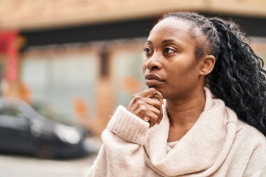African american woman standing with doubt expression at street