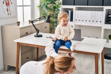 Mother and son having pediatrician consultation and playing at clinic