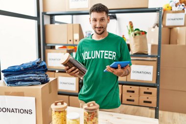 Yardım merkezinde dokunmatik ped kullanan gönüllü üniformalı bir İspanyol genç.