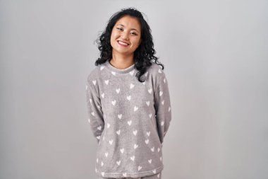 Young asian woman wearing pajama with a happy and cool smile on face. lucky person. 