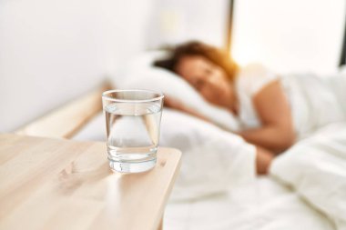 Orta yaşlı İspanyol kadın yatak odasında yatakta uyuyor.