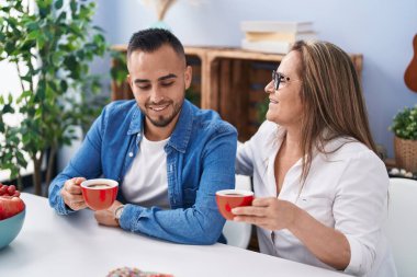 Man and woman mother and son drinking coffee at home