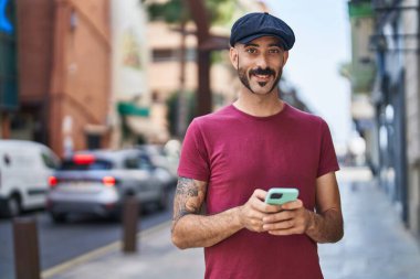 Sokakta akıllı telefon kullanan, kendine güvenen genç bir İspanyol.