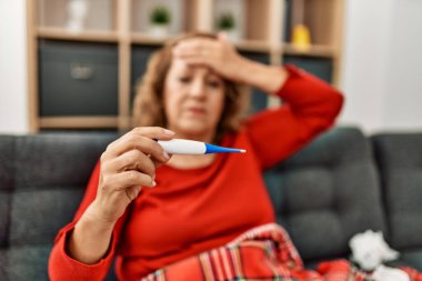 Orta yaşlı, beyaz, hastalıklı kadın. Evdeki kanepede oturuyor..