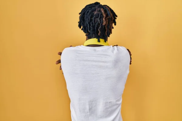 Young African Man Dreadlocks Standing Yellow Background Hugging Oneself Happy — Stock Photo, Image