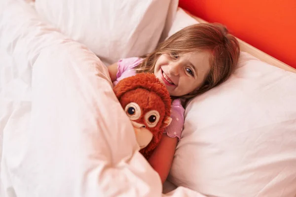 Sevimli Spanyol Kız Yatak Odasında Uzanmış Maymun Bebeğine Sarılıyor — Stok fotoğraf