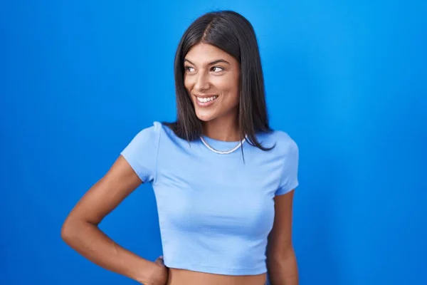 Brunette Young Woman Standing Blue Background Looking Away Side Smile — Stock fotografie