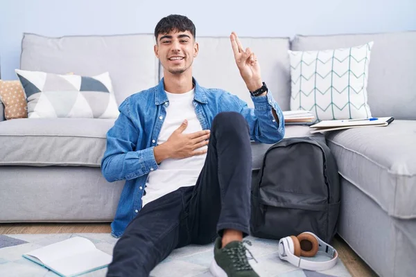 Young Hispanic Man Sitting Floor Studying University Smiling Swearing Hand — Zdjęcie stockowe