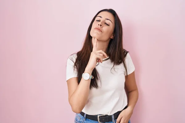 Young Brunette Woman Standing Pink Background Thinking Concentrated Doubt Finger — ストック写真