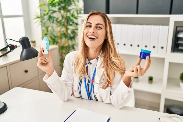 Young Blonde Doctor Woman Holding Medicine Products Breath Better Smiling — Fotografia de Stock