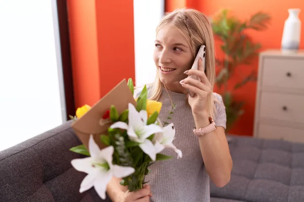 Junge Blonde Frau Spricht Auf Smartphone Und Hält Blumenstrauß Hause — Stockfoto