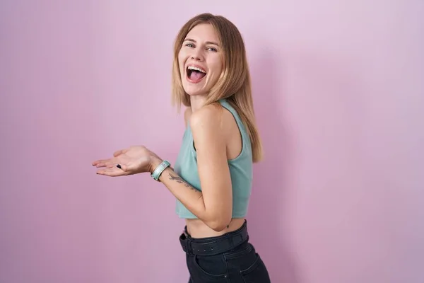 Blonde Caucasian Woman Standing Pink Background Pointing Aside Hands Open — Foto Stock