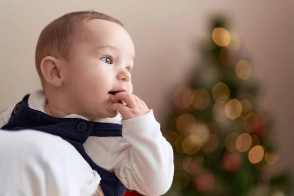 Sevimli Çocuk Evde Anne Kollarında Noel Ağacının Yanında Parmak Emiyor — Stok fotoğraf