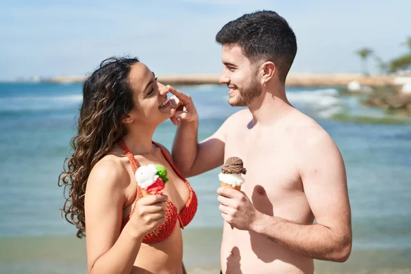 Young Hispanic Couple Tourists Wearing Swimsuit Eating Ice Cream Seaside — Fotografia de Stock