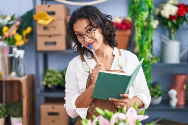 Young Beautiful Hispanic Woman Florist Smiling Confident Reading Notebook Flower — Stockfoto