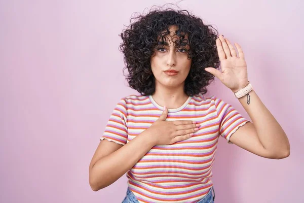 Young Middle East Woman Standing Pink Background Swearing Hand Chest — Stok fotoğraf