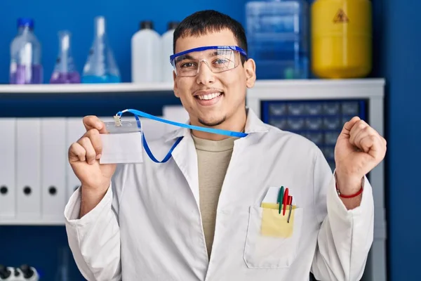 Idカードを持っている科学研究所で働いている若い研究室の男は誇りに思って叫んで 勝利と成功を祝う非常に興奮して腕を上げ — ストック写真