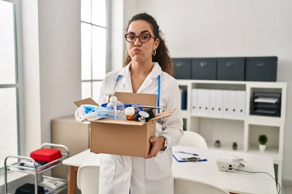 Young Hispanic Woman Holding Box Medical Items Puffing Cheeks Funny — Fotografia de Stock