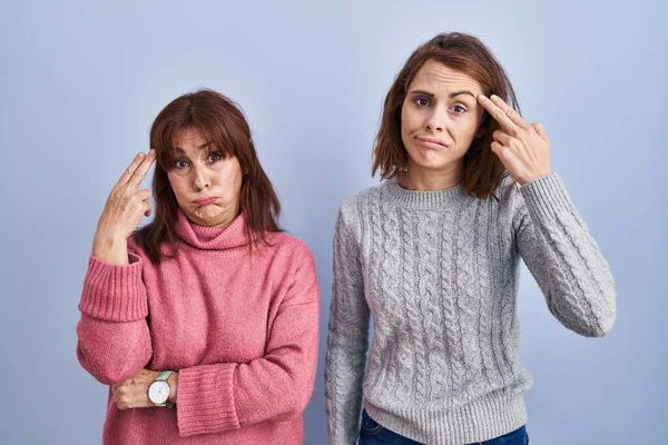 Mother Daughter Standing Blue Background Shooting Killing Oneself Pointing Hand — Stockfoto