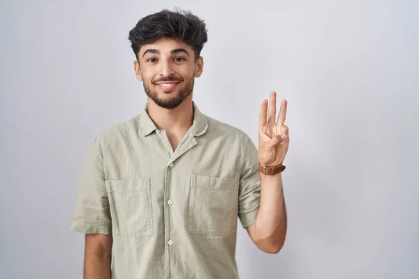 自信と幸せ笑顔ながら 白い背景が表示され 指の数3で指摘し 髭を生やしているアラブ人の男 — ストック写真