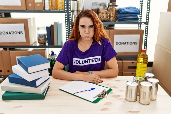 Young Redhead Woman Wearing Volunteer Shirt Donations Stand Puffing Cheeks — Stock Photo, Image
